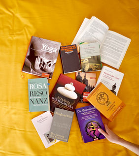 Bücher zu Yoga und Philosophie auf gelbem Untergrund