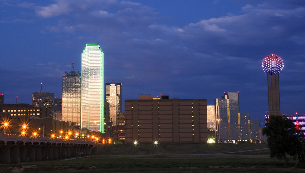 Dallas skyline at night with green building and Reunion Tower