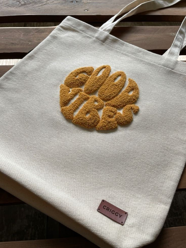 Criggy tote bag with "Good Vibes" embroidery in a circular design on a light-colored canvas.