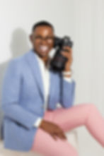 Smiling photographer in a blue blazer holding a camera