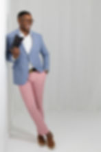 Man in blue blazer and pink trousers smiling