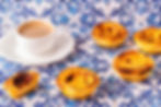 A cozy image of a plate of crispy, golden-brown chicche served alongside a steaming cup of creamy white coffee, inviting warmth and comfort.