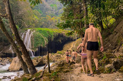 Visitors hiking jungle trail at Semuc Champey Lanquin Guatemala