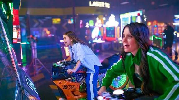 Two women playing racing arcade motorcycles at Main Event bowling and arcade center in Knoxville