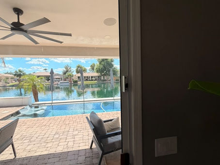 High safety latch mounted at the top of a sliding patio door, out of children's reach, overlooking a backyard pool in Arizona
