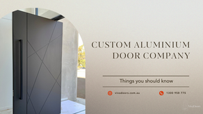 Sleek black custom aluminium door with geometric design. Text reads "Custom Aluminium Door Company." Contact info: vivadoors.com.au.