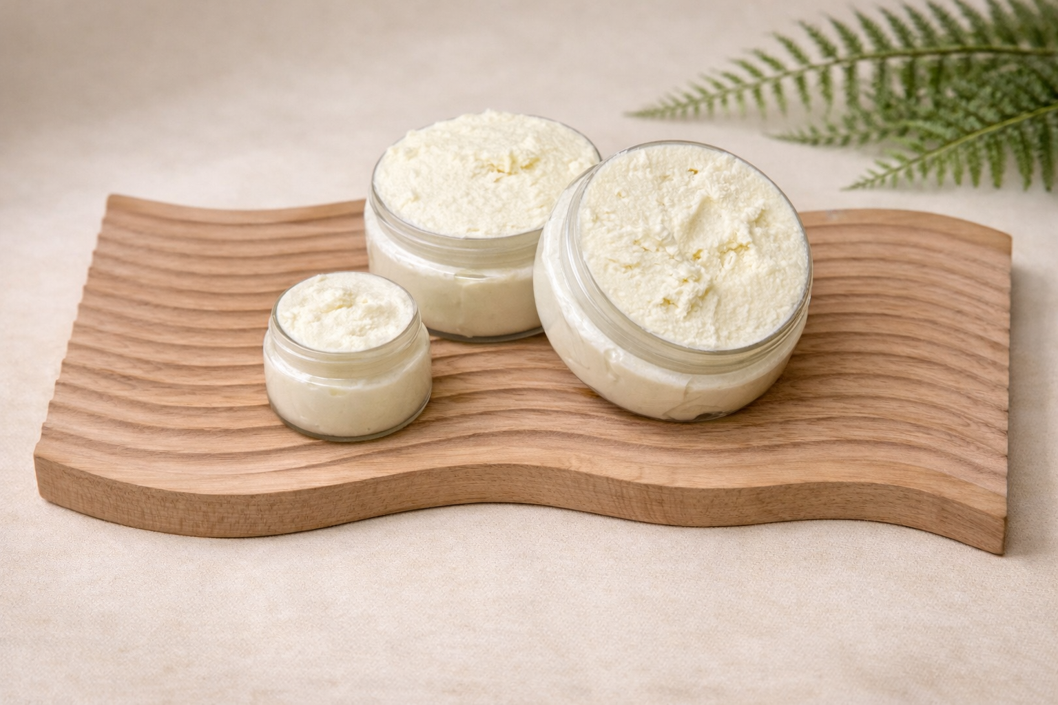 Tranquessence lavender mint whipped shea butter displayed in clear jars on a natural wood tray with botanical styling.