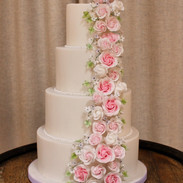 Fondant covered cake with cascade of handmade sugar roses and flowers