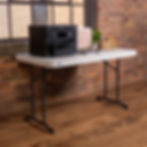 Table LIFETIME avec plusieurs objets posés dessus devant un mur de briques