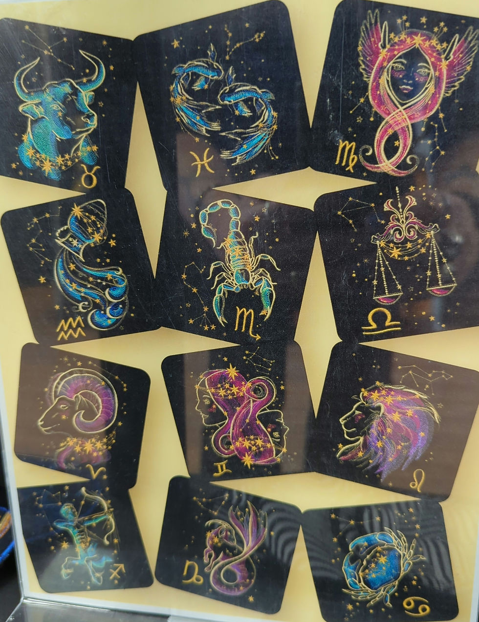 Astrological symbol cards, vibrant colors, against a yellow background. Each card features a zodiac sign with stars and mystical patterns.
