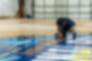 worker painting 2025 women's final four court logo