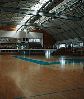 Empty school gymnasium with open ceiling structure