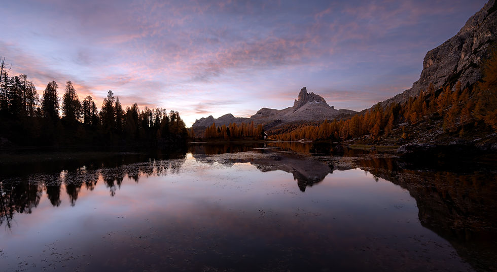 Lago Federa in the Dolomites at early morning twilight, with purple skies and Becca di Mezzodì reflected in still water.