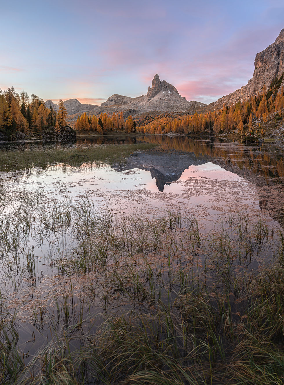Sunrise at Lago Federa in the Dolomites with purple sky and Becco di Mezzodì reflected in the water