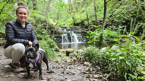 Nicola with a dog next to a waterfall