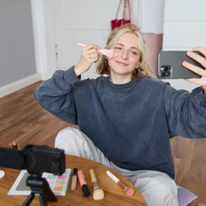 Dospívající dívka natáčí video na sociální sítě a líčí se před telefonem a kamerou. Článek o tom, proč chtějí dospívající být influenceři, jak online svět ovlivňuje adolescentní mozek, potřebu uznání, identity a hledání budoucího povolání.
