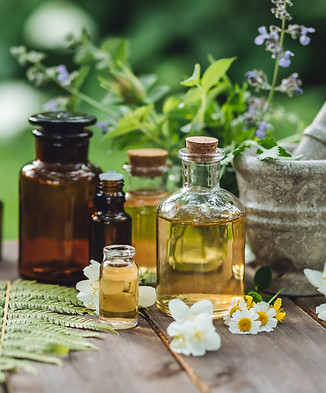 Assortment of pure organic natural essential aroma oil with mint , camomile on wooden back