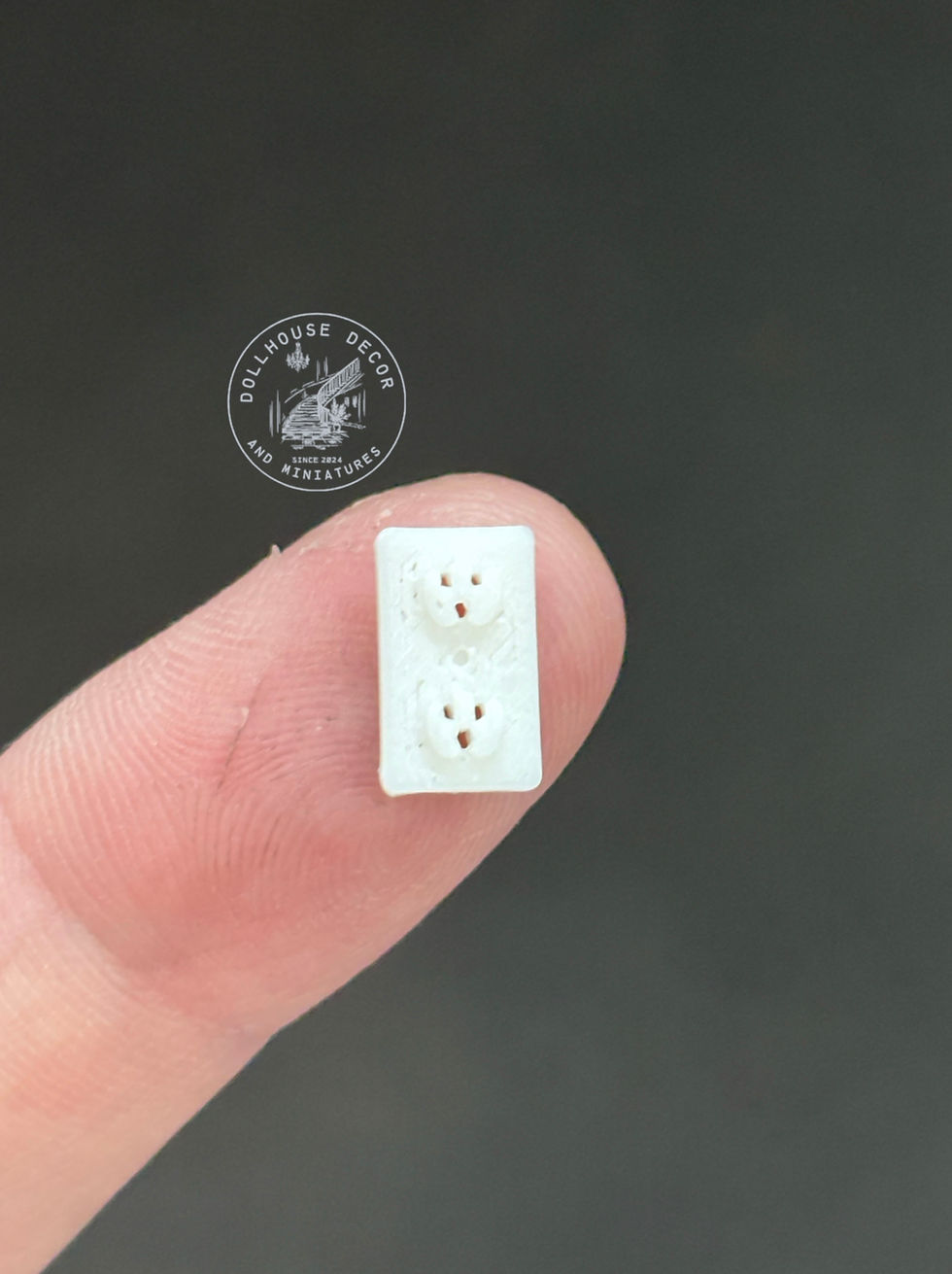 Pack of four 1:12 scale miniature power points shown on a fingertip for size comparison.