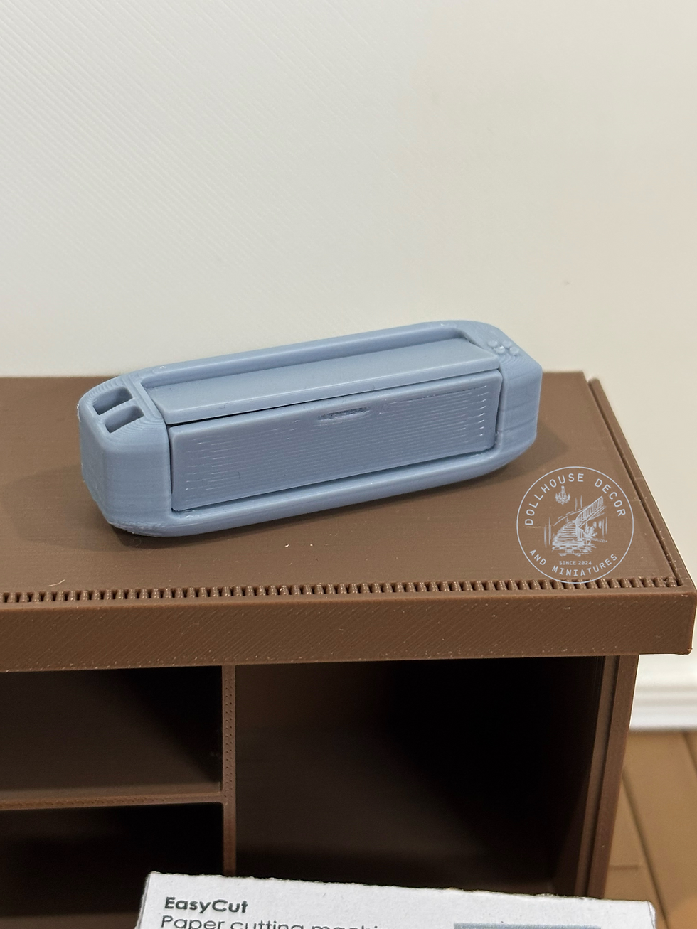 Thumbnail: Closed grey 1:12 scale miniature electronic paper cutting machine for a dollhouse craft room.