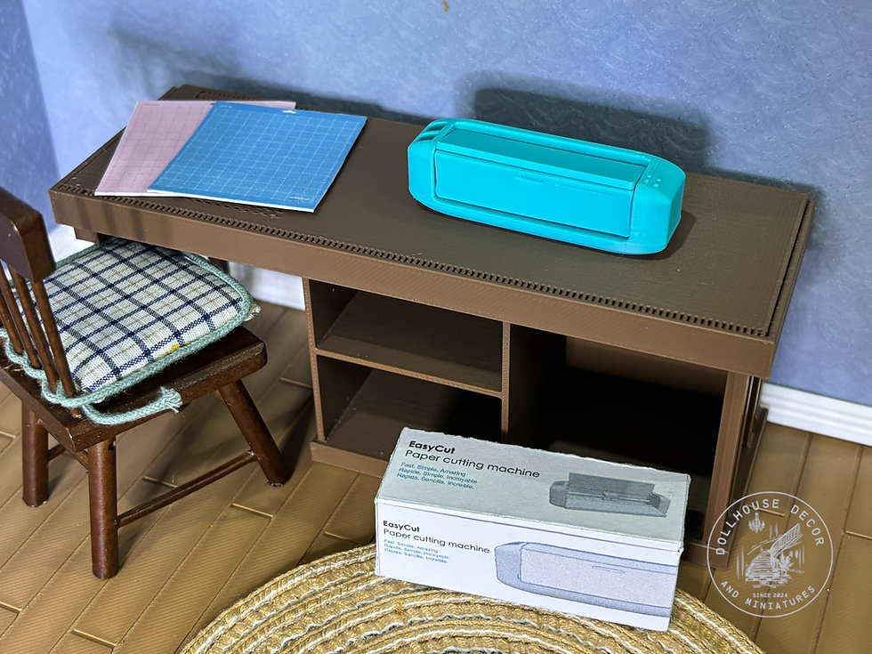 Thumbnail: 1:12 scale miniature electronic paper cutting machine with printed retail packaging in a realistic dollhouse craft room.