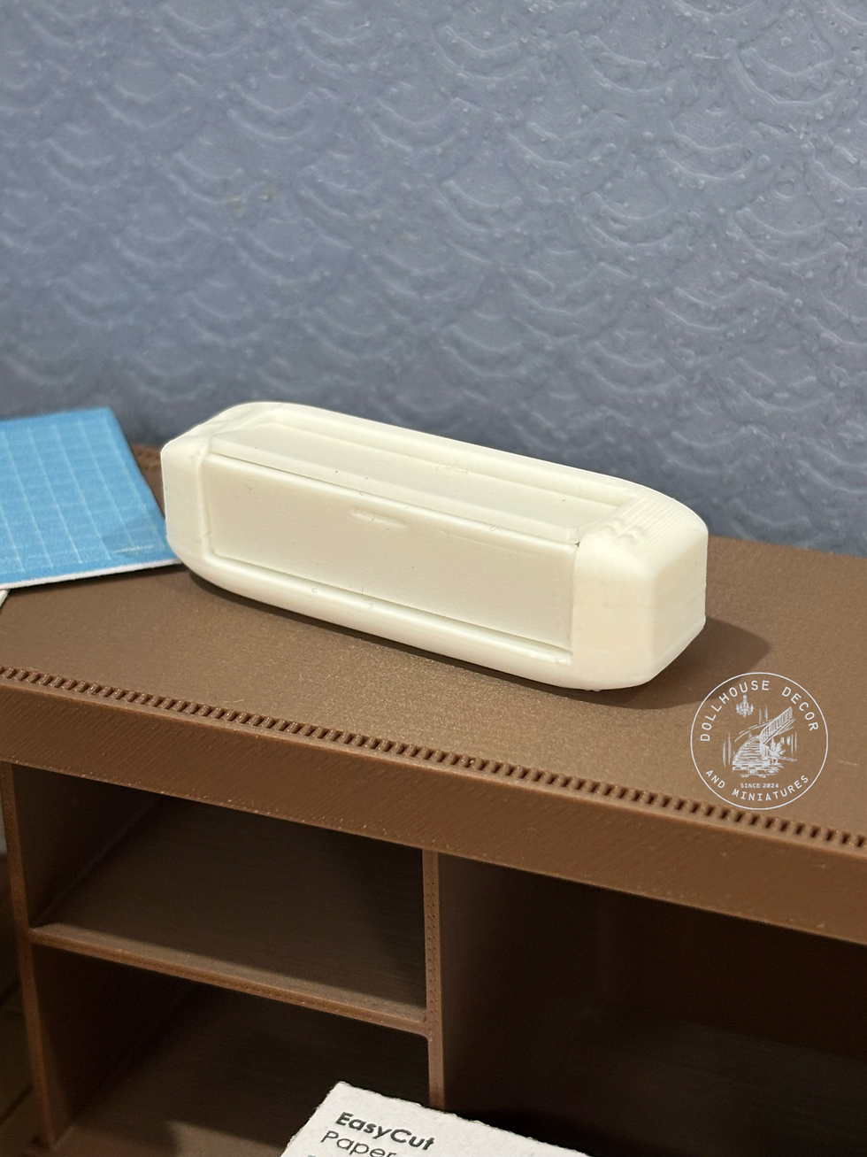 Thumbnail: Closed white 1:12 scale miniature electronic paper cutting machine for a dollhouse craft room.