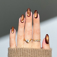 Female hand with oval-shaped light brown cat-eye nails for the fall season Nail art Glitte
