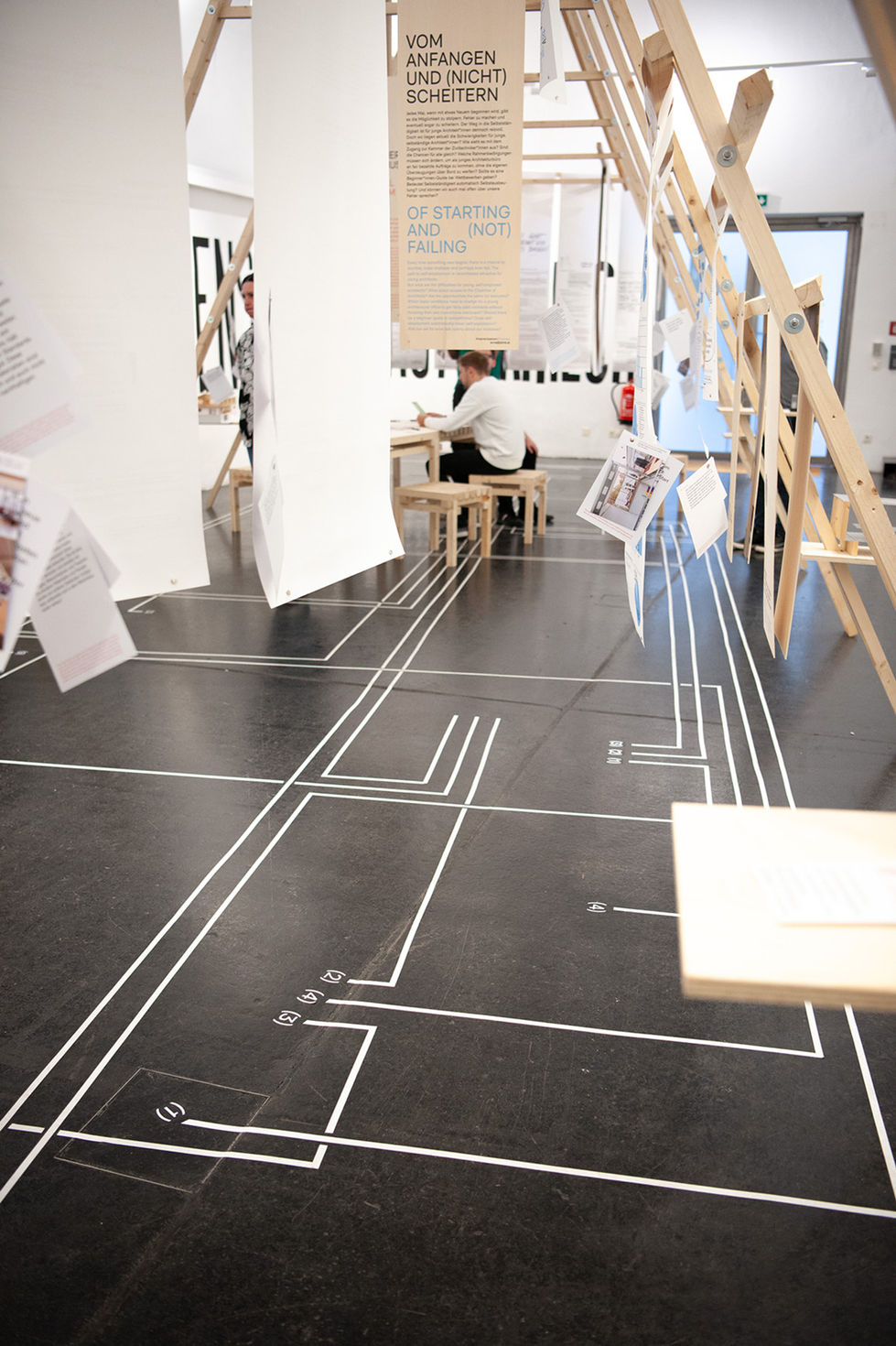 bedruckte Plakate und Holztafeln in einer Ausstellung über Architektur