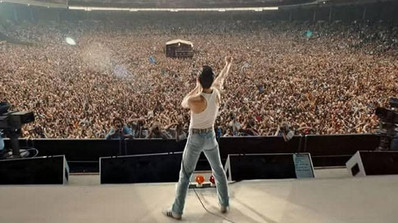 Queen en pleno concierto: Freddie Mercury liderando con su carisma único y su poderosa voz.