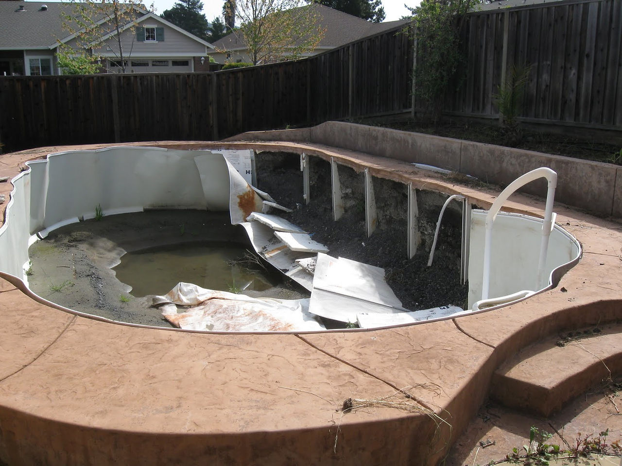 This above ground pool that was buried collapsed under the weight of the backfill once the water was removed from the pool.