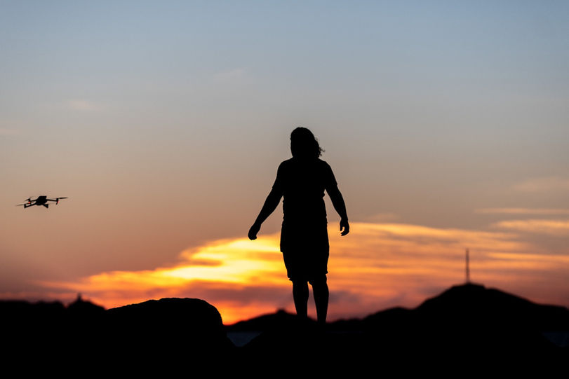 Silhouette d'une personne regardant drone voler au coucher de soleil, Drone Aix en Provence