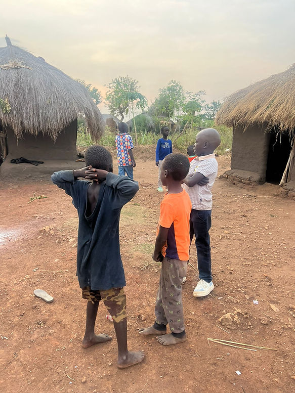 Children standing in a village with huts