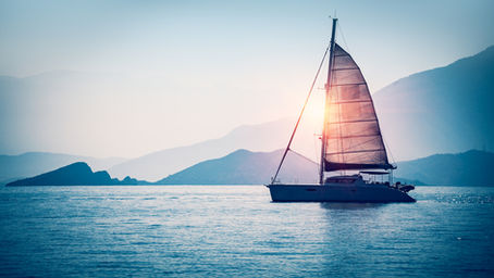 Mid-size cruising sailboat anchored in calm blue water