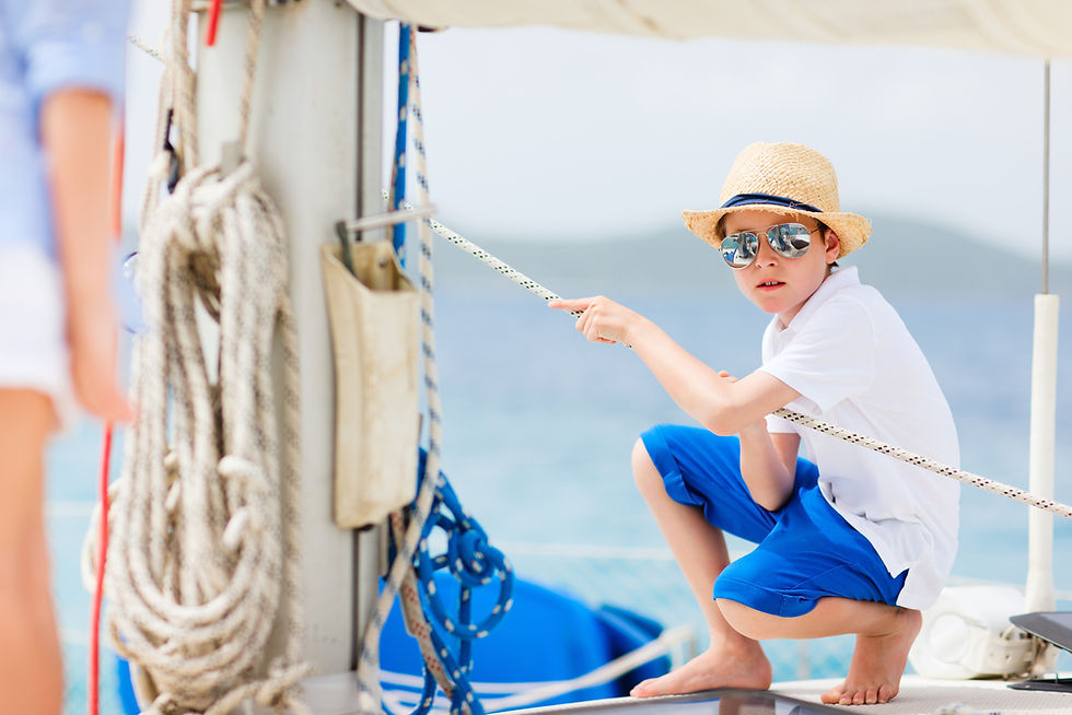 Mother and son sitting together on the deck of a sailboat at sunset during a family sailing trip.