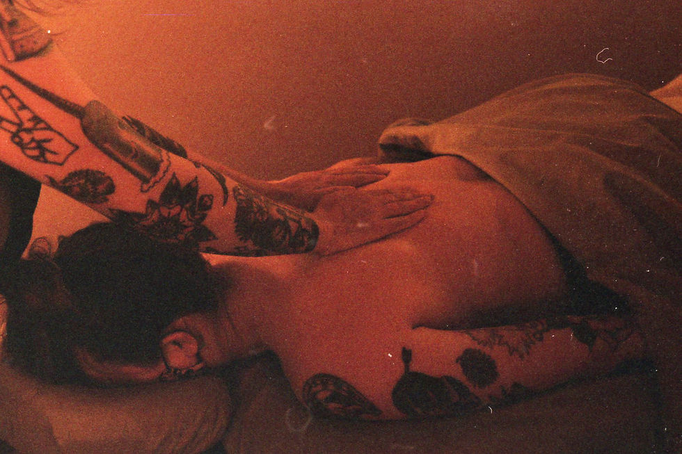Film photograph on hands on a back of someone laying on a massage table