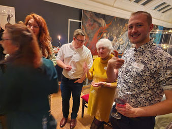 Group celebrating at a party; woman gives thumbs up