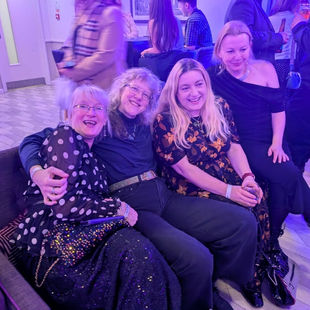 Four women smiling at a party