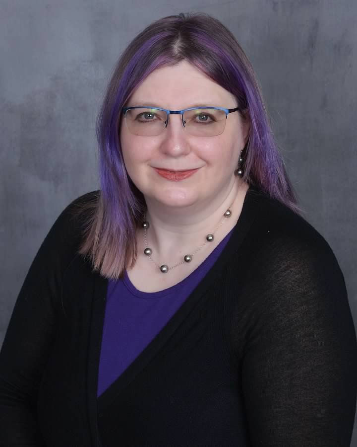 Headshot of author with purple hair