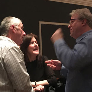 Three people conversing animatedly at a gathering