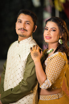 Smiling couple at their mehndi ceremony in Uttarakhand wearing coordinated yellow and green outfits