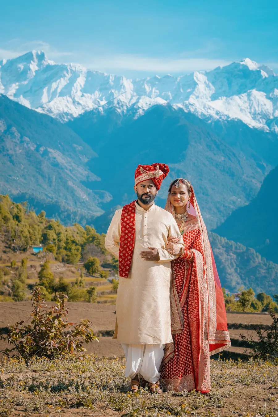 Indian wedding couple portrait with scenic mountain backdrop in traditional attire