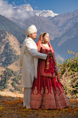 Couple in traditional attire on their wedding day with mountain backdrop