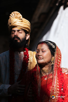 Close-up of Indian groom in golden turban with bride in red saree at Triyuginarayan Temple