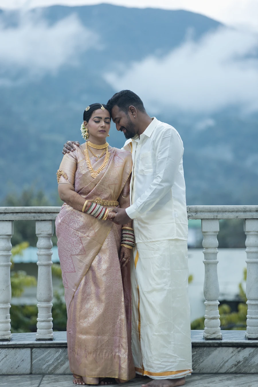 Bride and groom in traditional South Indian wedding attire sharing an intimate moment at a scenic hilltop venue in Uttarakhand