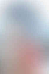 Bride and groom in traditional attire smiling with Triyuginarayan temple behind them.