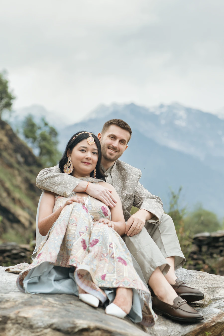 A relaxed and intimate portrait set against the mountains, blending tradition with natural beauty.