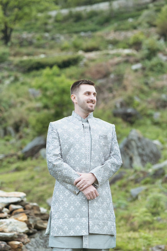 Groom smiling in grey sherwani during pre-wedding shoot at Triyuginarayan Temple Uttarakhand