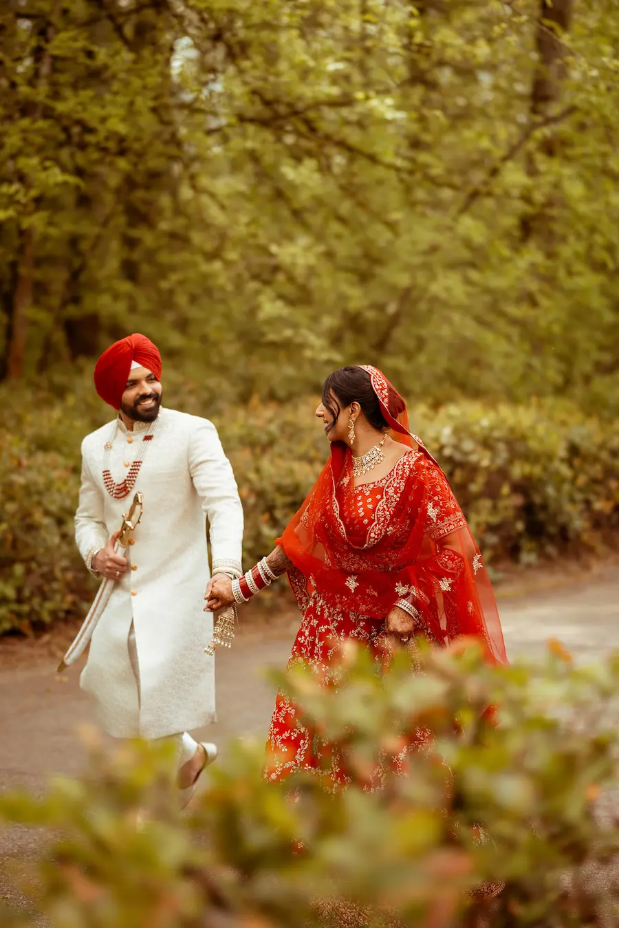 Indian wedding couple walking together outdoors in traditional attire during a ceremony