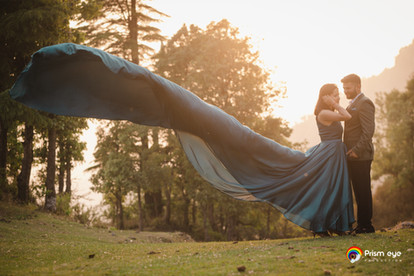 Bride twirling in flowy teal gown in open landscape