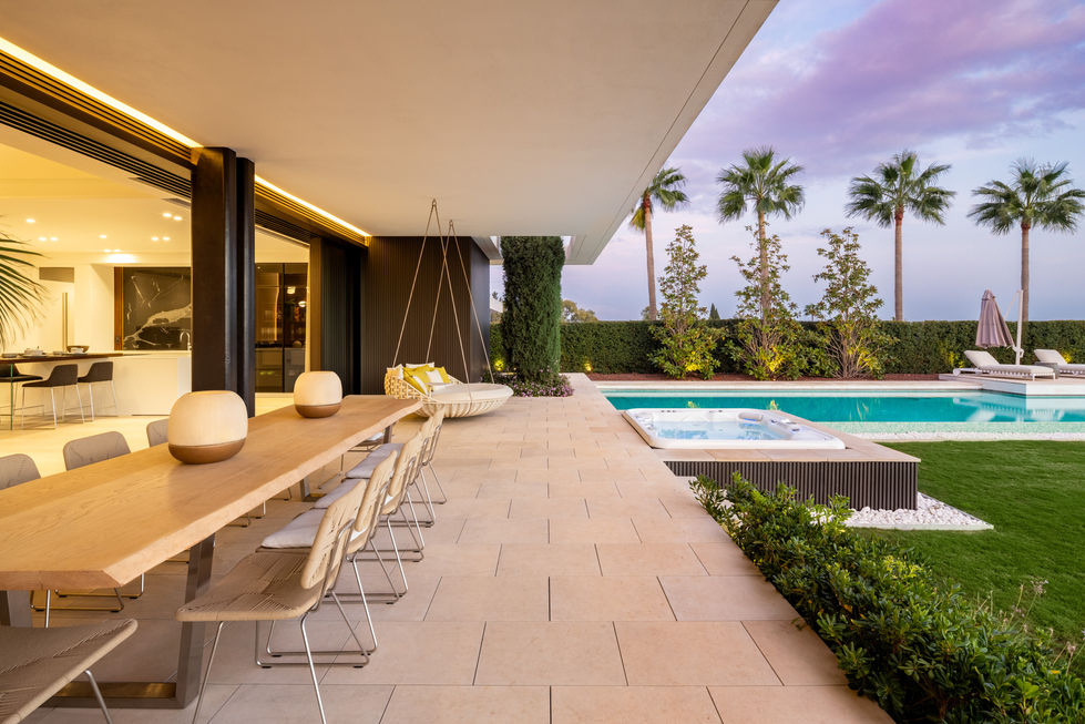 a patio with a table and chairs next to a pool