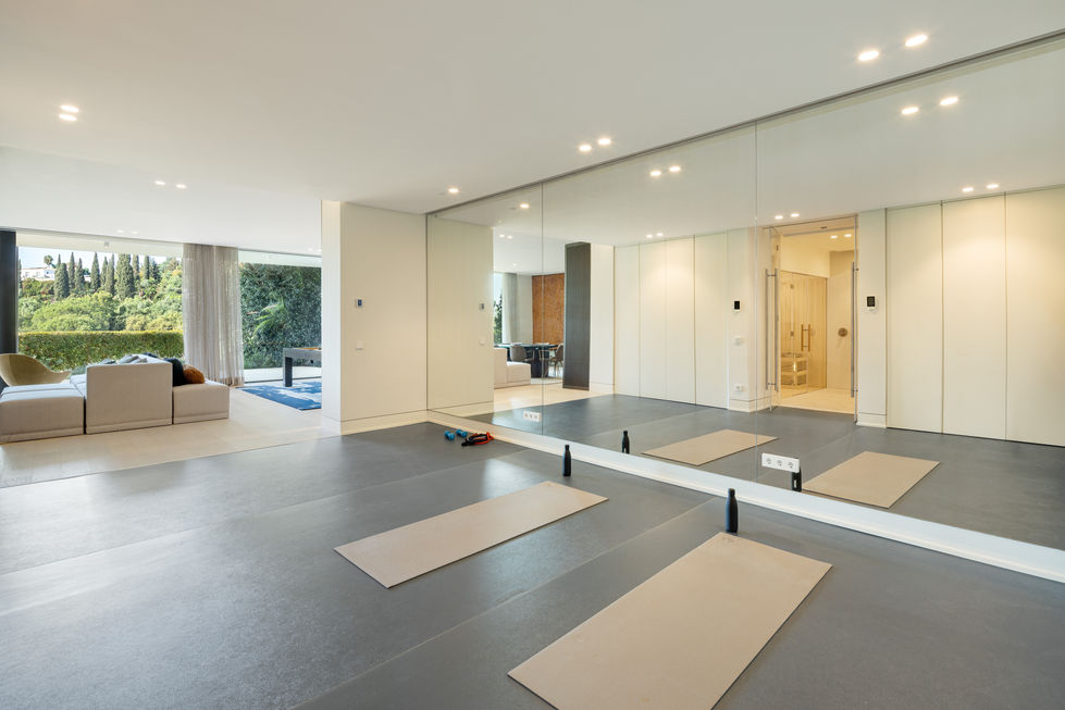 a gym with a large mirror and yoga mats on the floor